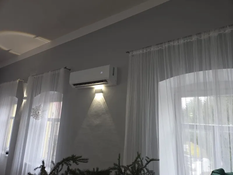 Biały klimatyzator AUX w eleganckim salonie — funkcja grzania